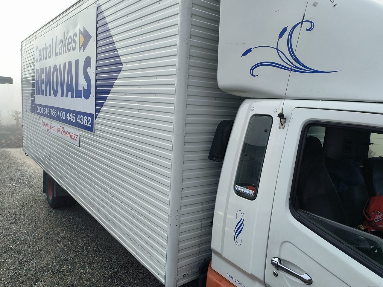 Central Lakes Removals truck viewed from the side in fog.